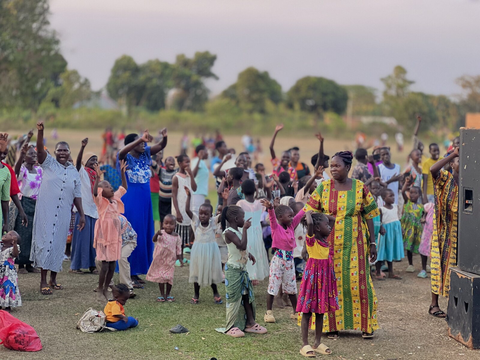 A crowd with hands raised in worship during an open-air gathering